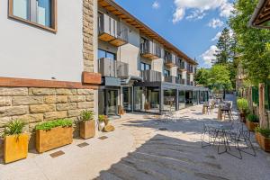 un bâtiment avec des chaises et des tables dans une cour dans l'établissement Boutique Via Roma 33 -Tuscany Experience - Hotel & Spa, à Stia