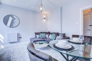 un soggiorno con divano e tavolo in vetro di Artsy Serviced Apartments - Victoria a Londra