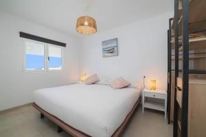 um quarto com uma cama branca e uma janela em Villa Garoé em Playa Quemada