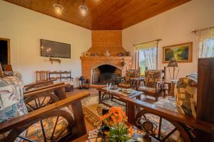 a living room with a fireplace and a couch at Pousada Rural Vista Alegre in Bom Jardim da Serra