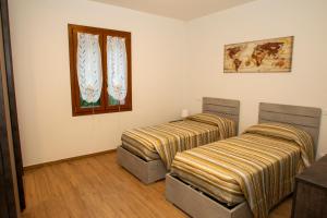Duas camas num quarto com uma janela em Modern Villa with jacuzzi and sauna near Tuscany em Monghidoro