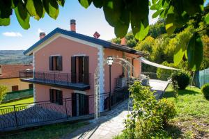 Uma casa cor-de-rosa com um portão à frente. em Modern Villa with jacuzzi and sauna near Tuscany em Monghidoro