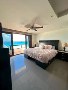 a bedroom with a bed with a ceiling fan at Amazing beachfront apartment in Cancún