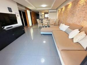 a living room with a couch and a flat screen tv at Amazing beachfront apartment in Cancún