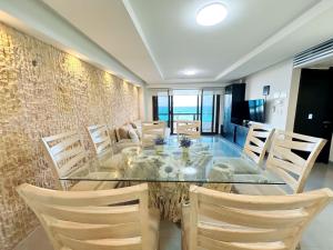 a dining room with a glass table and chairs at Amazing beachfront apartment in Cancún