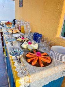 a long table with plates of food on it at Samburá Suítes in Japaratinga