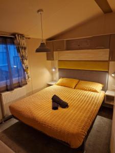 un dormitorio con una cama amarilla con sombrero en Bird Lake Pastures Holiday Caravan, en Northampton