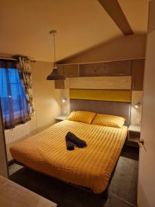 1 dormitorio con 1 cama con sombrero en Bird Lake Pastures Holiday Caravan, en Northampton