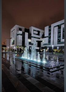 a building with a fountain in front of it at night at Spacious Apt in Rabat Hay Riad in Rabat