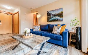 a living room with a blue couch and a table at Cozy 2 Bedroom with Mountain View Banff Getaway in Canmore