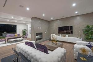 een woonkamer met witte meubels en een open haard bij Skyline Luxury Haven in Los Angeles