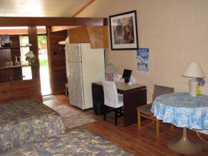 a bedroom with a desk and a bed and a table at Motel Le Charentais in Sorel