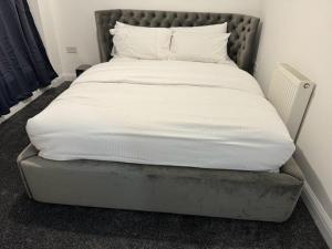 a bed in a room with a white mattress at LUXURY APARTMENTS in Dagenham