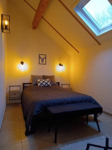een slaapkamer met een bed en een dakraam bij Maison des Fées d'Achouffe in Houffalize