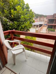 een witte stoel op een balkon met uitzicht bij Kitnet no Melhor Ponto de Bombinhas in Bombinhas