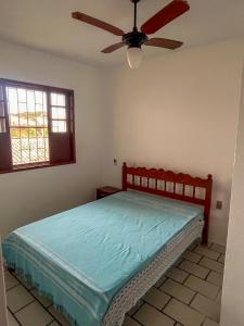 een slaapkamer met een bed en een plafondventilator bij Kitnet no Melhor Ponto de Bombinhas in Bombinhas