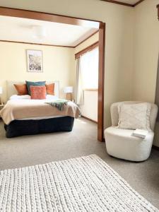 a bedroom with a bed and a chair at Studio 6 at Tui Treehouse Stay Auckland in Auckland