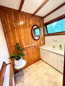 a bathroom with a sink and a mirror at Studio 6 at Tui Treehouse Stay Auckland in Auckland