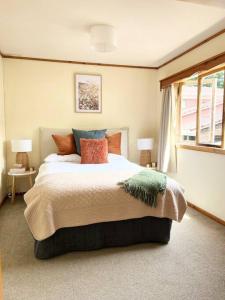 a bedroom with a large bed and a window at Studio 6 at Tui Treehouse Stay Auckland in Auckland