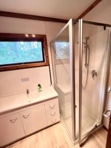 a bathroom with a shower and a sink at Studio 6 at Tui Treehouse Stay Auckland in Auckland