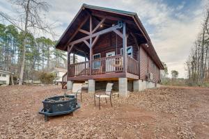 ein Blockhaus mit einer Terrasse und Stühlen im Hof in der Unterkunft Troy Cabin with River Access Fish, Kayak and More! in Troy