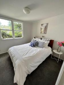 een slaapkamer met een groot bed met witte lakens en kussens bij Herne Bay 1 Bedroom Apartment - Stay Auckland in Auckland
