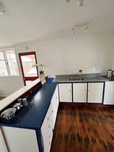 een keuken met witte kasten en een blauw aanrecht bij Herne Bay 1 Bedroom Apartment - Stay Auckland in Auckland
