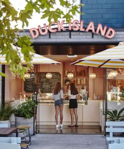 twee vrouwen die buiten een lul eiland restaurant staan bij Herne Bay 1 Bedroom Apartment - Stay Auckland in Auckland