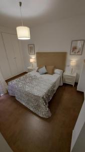 a bedroom with a bed and two tables and two lamps at Apartamento moderno vacacional in Águilas