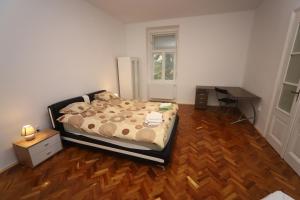um quarto com uma cama e piso em madeira em Ibolya Apartman Szeged em Szeged
