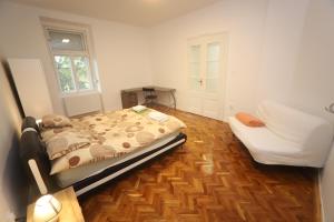 um quarto com uma cama e um sofá em Ibolya Apartman Szeged em Szeged