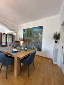 uma sala de jantar com uma mesa de madeira e cadeiras azuis em 2 BD Apt in Syntagma with Acropolis view em Atenas