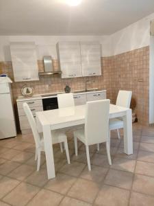 kuchnia z białym stołem i białymi krzesłami w obiekcie Domus underground w mieście Ripa Teatina