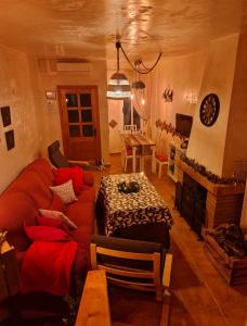 a living room with a red couch and a table at Entre Vistas in Zahara de la Sierra