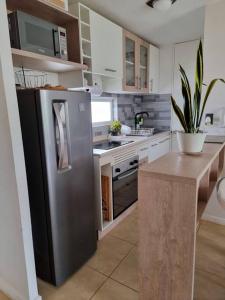 a kitchen with a stainless steel refrigerator and a counter at Condominio Miramar El Tabito in El Tabo