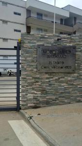 a sign on the side of a brick wall at Condominio Miramar El Tabito in El Tabo