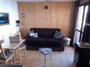 a living room with a black couch and a table at Studio cosy Wifi Les Deux Alpes centre in Les Deux Alpes