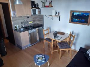 a small kitchen and a table with a laptop on it at Studio cosy Wifi Les Deux Alpes centre in Les Deux Alpes