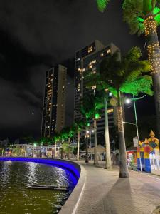 a city at night with a pond and buildings at Pousada Açude Velho in Campina Grande
