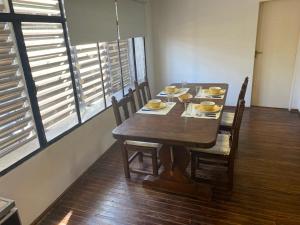 a dining room table with chairs and a wooden table with food on it at Departamento Avenida in Santo Tomé