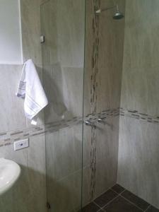 a shower with a glass door next to a sink at Confort en zona ecológica, Loft en Pilarica 2 in Medellín