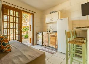 uma cozinha com um frigorífico branco e uma mesa em Pousada do Paraiso em Barra de Ibiraquera