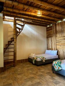 a bedroom with a bed and a spiral staircase at La Veranda Hotel & Restaurant in Minca