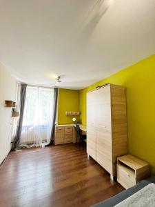 クラクフにあるCosy room Aleja Kijowskaの黄色い壁のベッドルーム1室、デスクが備わる客室です。