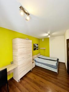 a bedroom with a bed and a yellow wall at Cosy room Aleja Kijowska in Krakow