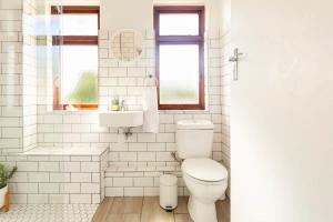Un baño blanco con inodoro y lavabo. en Innie Baai Beach House, en Ciudad del Cabo 22 fotos más