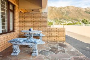 una mesa y dos bancos sentados en un patio en Innie Baai Beach House, en Ciudad del Cabo