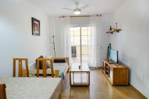 ein Schlafzimmer mit einem Bett, einem Fernseher und einem Tisch in der Unterkunft Piscina playa y relax en familia in Roquetas de Mar