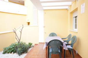 einen Tisch und Stühle auf der Veranda eines Gebäudes in der Unterkunft Piscina playa y relax en familia in Roquetas de Mar
