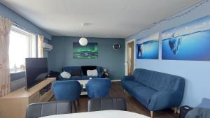 ein Wohnzimmer mit blauen Stühlen und einem Tisch in der Unterkunft Ilulissat Apartment in Ilulissat